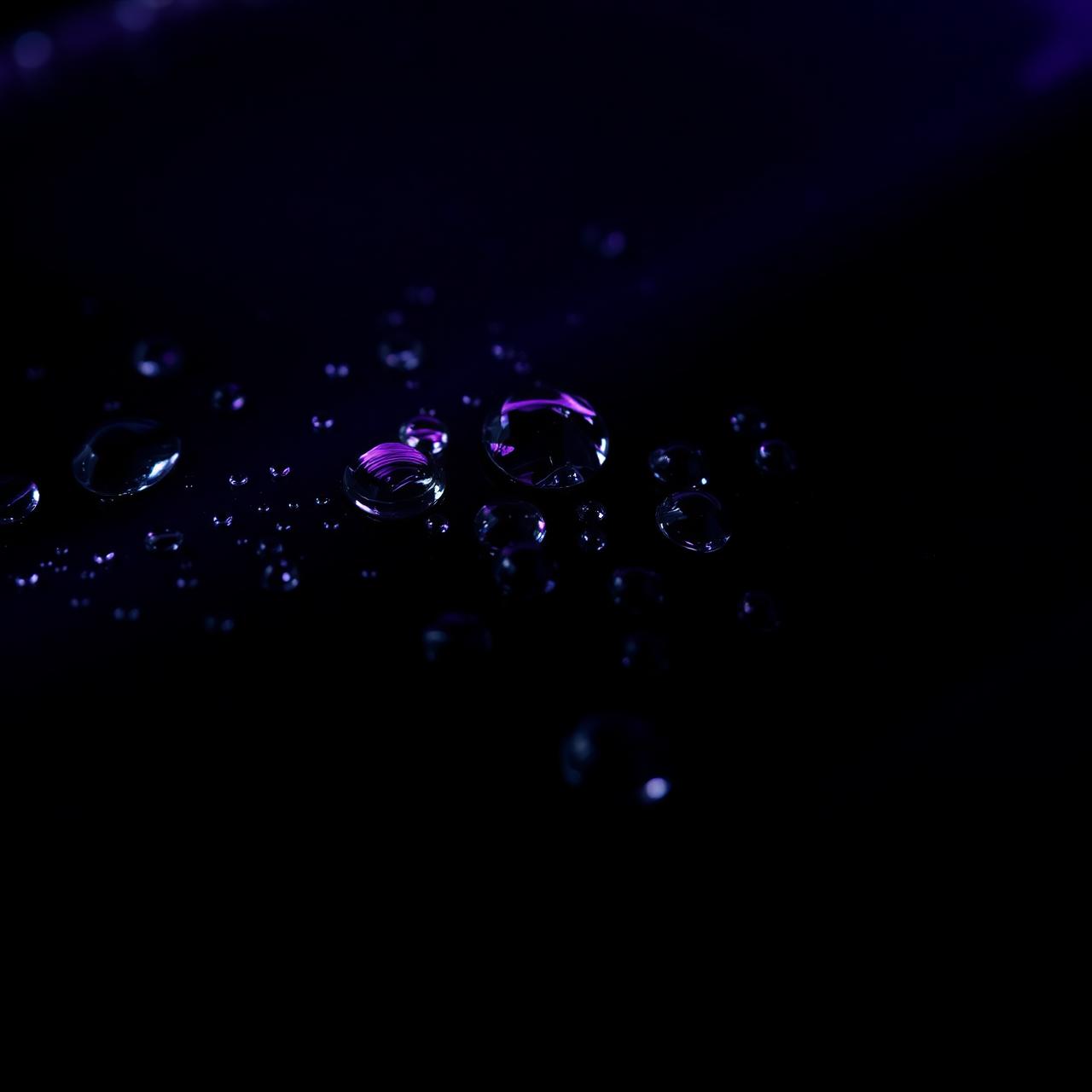 Macro of water beads on ceramic-coated black paint